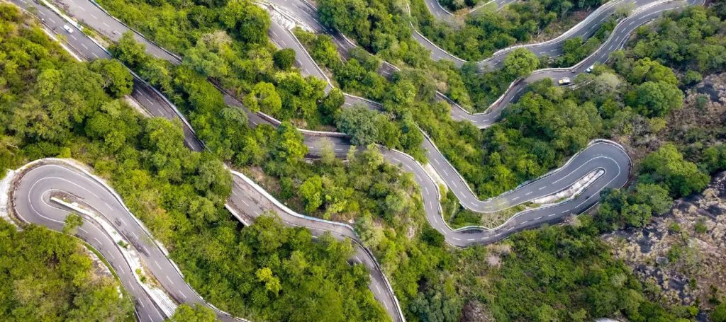 A breathtaking bird’s eye view of Yercaud’s hairpin bends, showcasing winding roads surrounded by lush green valleys and misty hills